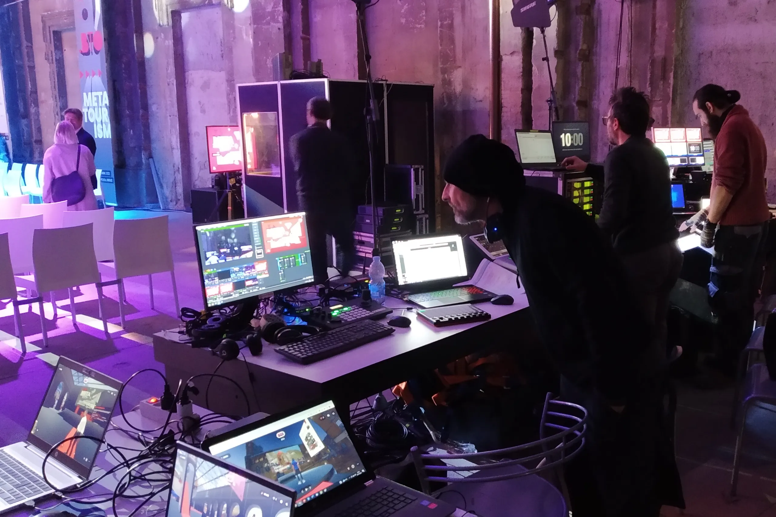Tecnici che fanno la messa a punto di una regia multicamera con contributi grafici e audio